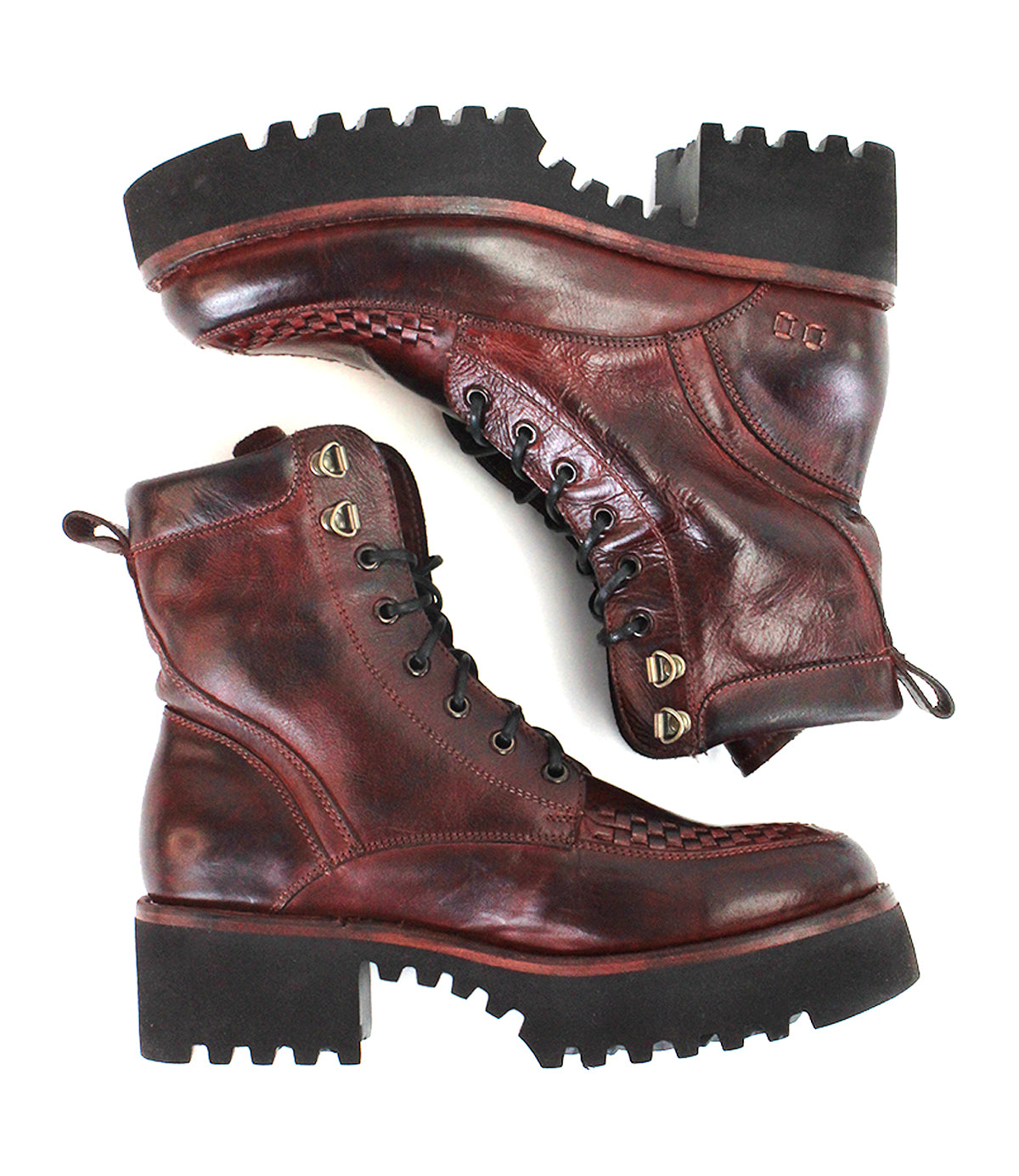 A pair of Bed|Stü Elisha Hi boots in rugged dark red leather, featuring a classic lace-up profile with metal eyelets and thick black treaded soles, are placed side by side against a white background.