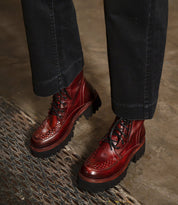 Bed|Stü Elisha Hi deep red leather platform shoes with a lace-up profile, handwoven moc-toe detail, and thick lugged soles.