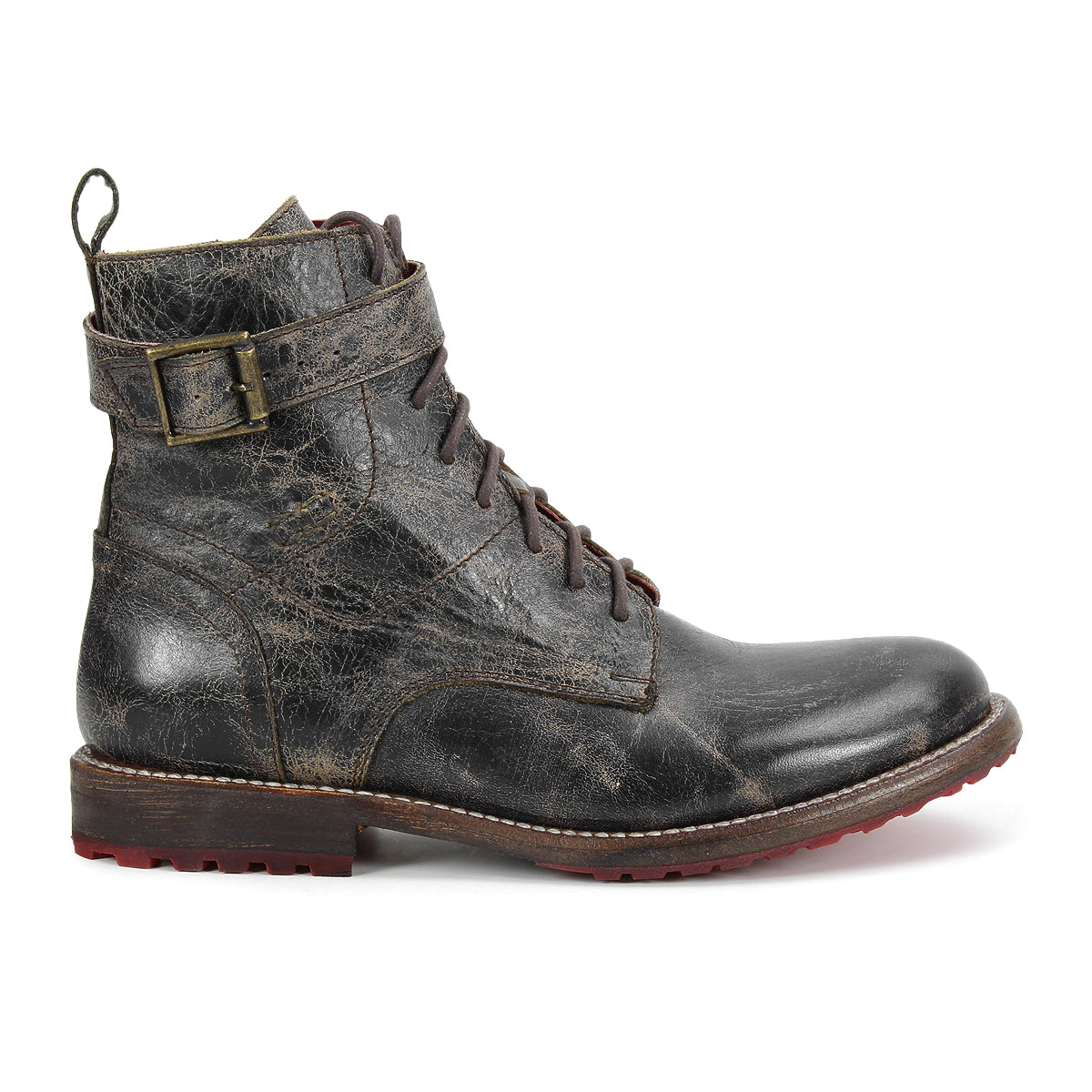 The Bed|Stü Endure boot is a single distressed black leather lace-up with a buckle strap, brown sole, durable treaded outsole, and slight heel, shown in a left side profile against a white background.
