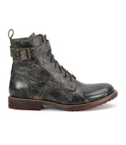 The Bed|Stü Endure boot is a single distressed black leather lace-up with a buckle strap, brown sole, durable treaded outsole, and slight heel, shown in a left side profile against a white background.