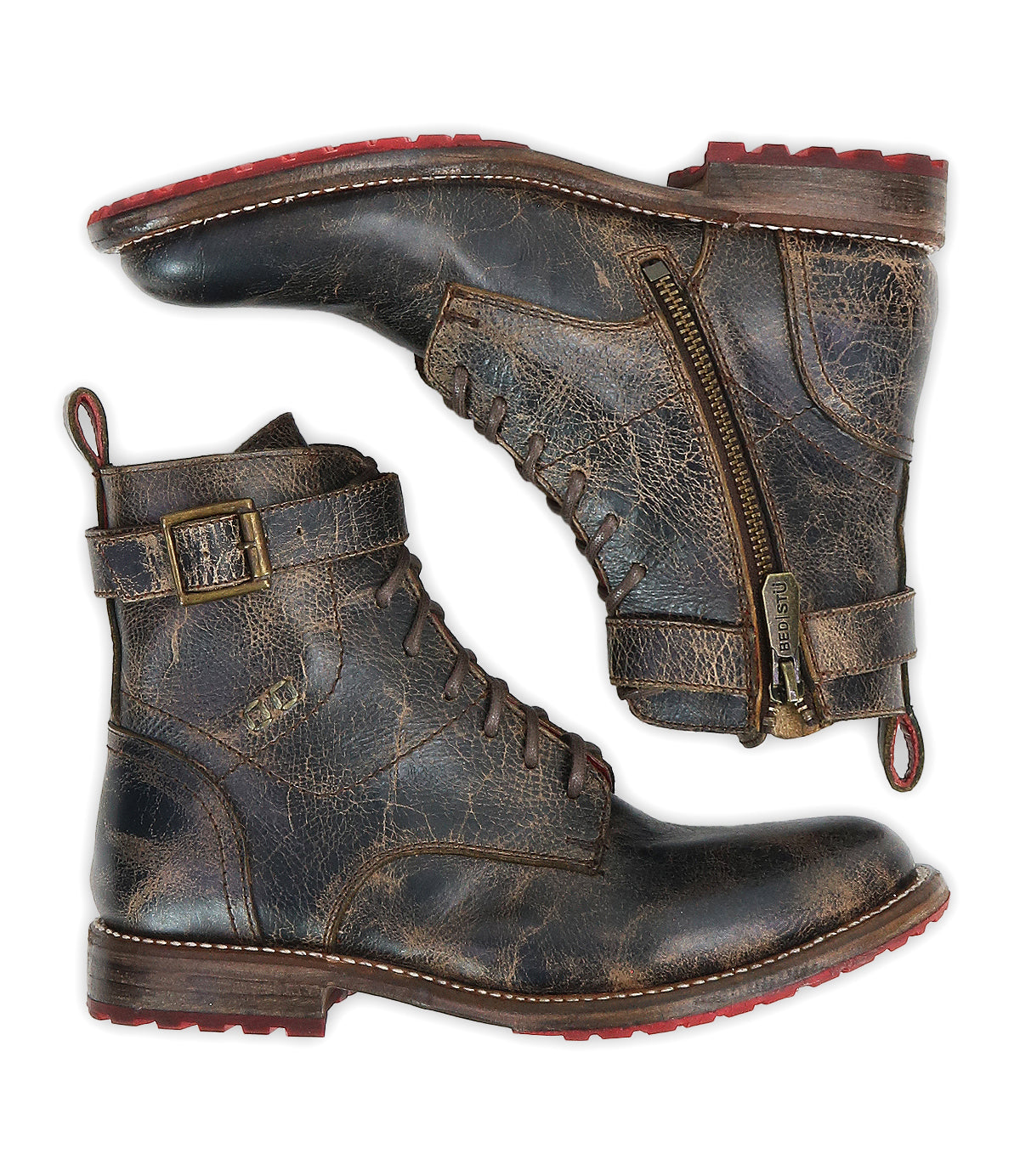 A pair of Bed|Stü Endure boots displayed side by side against a white background, showcasing rugged brown leather with lace-up fronts, side zippers, secure ankle straps with buckles, and bold red rubber soles featuring a durable treaded outsole.