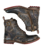 A pair of Bed|Stü Endure boots displayed side by side against a white background, showcasing rugged brown leather with lace-up fronts, side zippers, secure ankle straps with buckles, and bold red rubber soles featuring a durable treaded outsole.