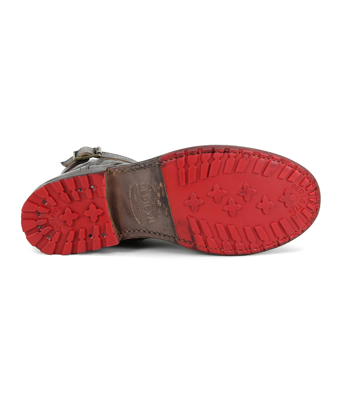A close-up view of the sole of the Bed|Stü Endure brown leather shoe is shown facing upward, highlighting its textured red rubber bottom and durable treaded outsole.