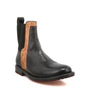 The Bed|Stü Ethic is a durable black leather Chelsea boot featuring brown trim, a red outsole, elastic side panels, and a pull tab at the back. Leather-lined for added comfort, it is displayed on a white background.
