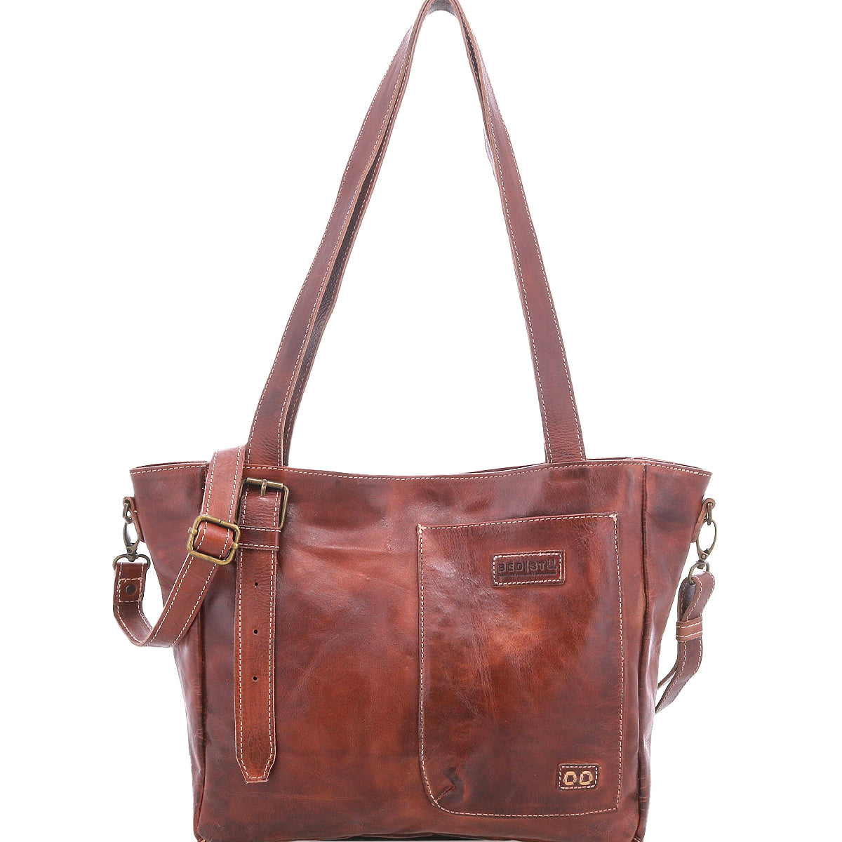 Meet the Explicit LTC by Bed|Stü—a brown leather shoulder bag featuring two sturdy handles, an adjustable strap, and a front pocket. Visible stitching and a small embossed Bed|Stü logo enhance its rustic charm. Designed for everyday dependability, this piece stands out beautifully against a plain white background.