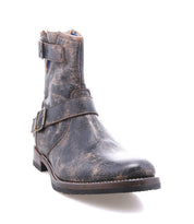 The Bed|Stü Fellow is a worn brown leather ankle moto boot with decorative side buckles and a low heel, featuring classic Goodyear welt construction, photographed on a white background.