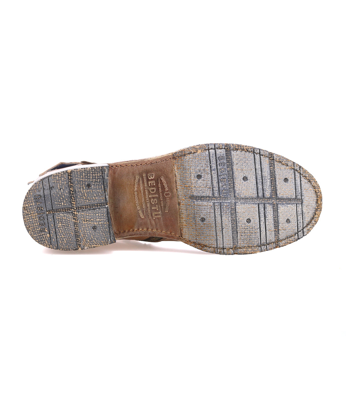 The sole of the Bed|Stü Fellow men's moto boot is shown from below, featuring textured rubber and leather sections, grid patterns, and visible branding—a rugged staple crafted with Goodyear welt construction for lasting durability.