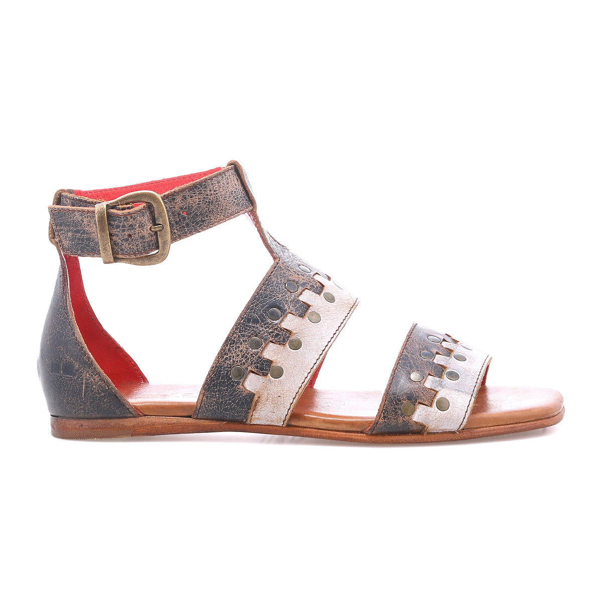 The Bed|Stü Fibril is a brown leather bohemian sandal, crafted from hand-woven leather, featuring an ankle strap with buckle closure and decorative cutout details on the straps, shown here in a side view.
