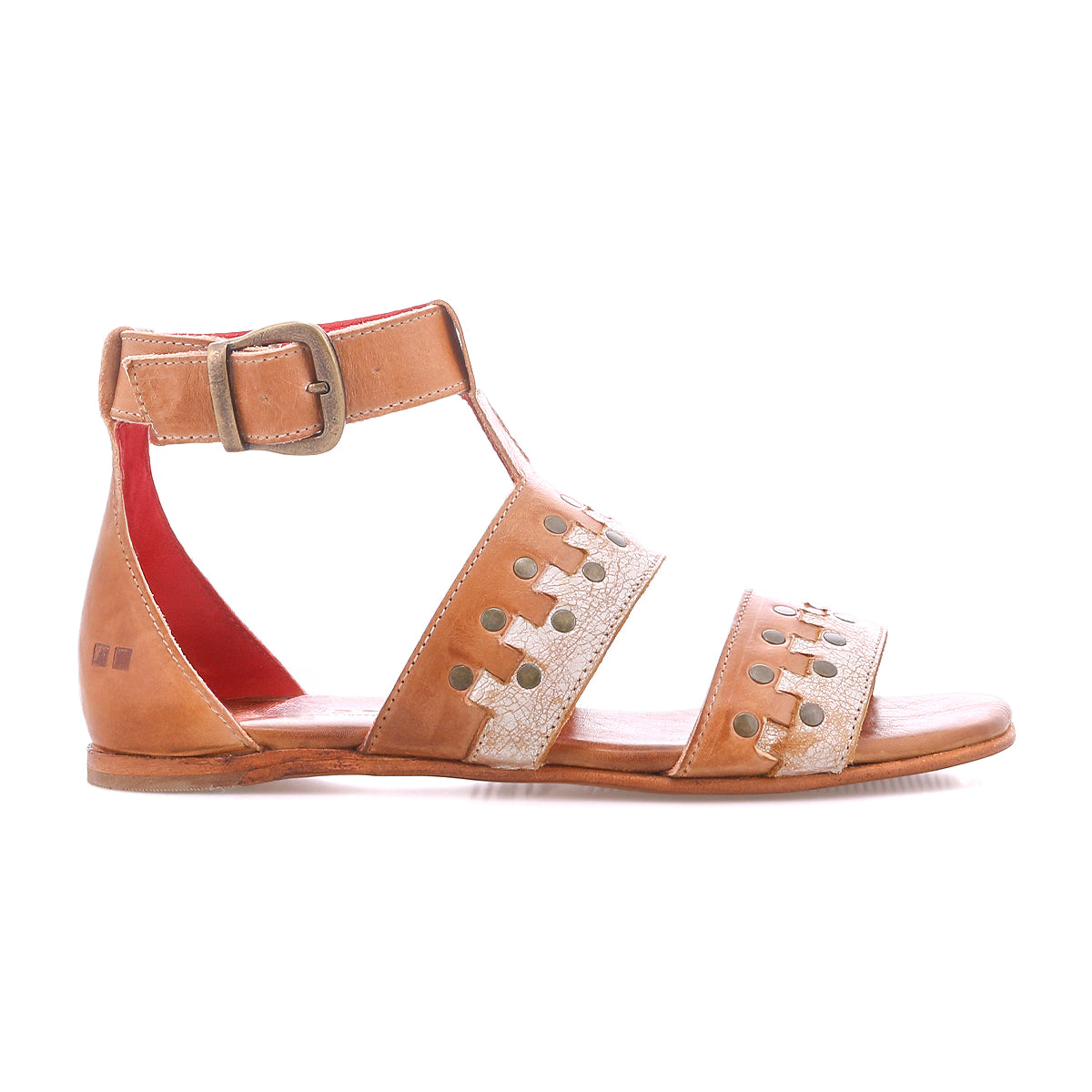 The Bed|Stü Fibril sandal is a brown leather bohemian flat with an adjustable ankle strap and buckle, two decorative hand-woven leather cutout straps across the foot, and a red inner lining, shown in a side view against a white background.