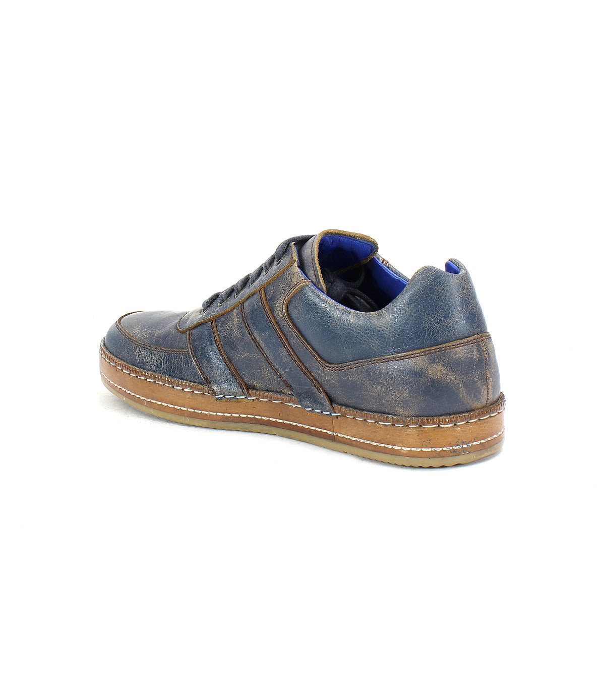 The Bed|Stü Firepower is an everyday blue leather sneaker with brown stitching, featuring subtle leather stripe details and a tan textured rubber sole, shown from the back left side against a white background.