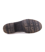 The underside of a worn, textured black shoe sole with visible tread patterns and the words “BESIO” and “GOODYEAR WELTED” embossed, highlighting the sturdy Goodyear welt construction featured in Bed|Stü's Fierce washed leather derby design.