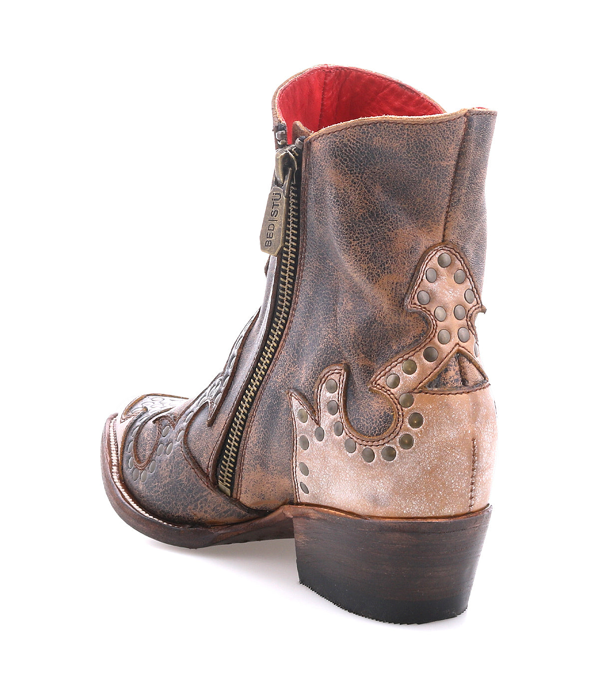 Frio by Bed|Stü: A distressed leather Western bootie ankle boot featuring decorative stitching, floral cutout detailing, antiqued brass studs, and a side zipper, displayed from the rear angle on a white background.