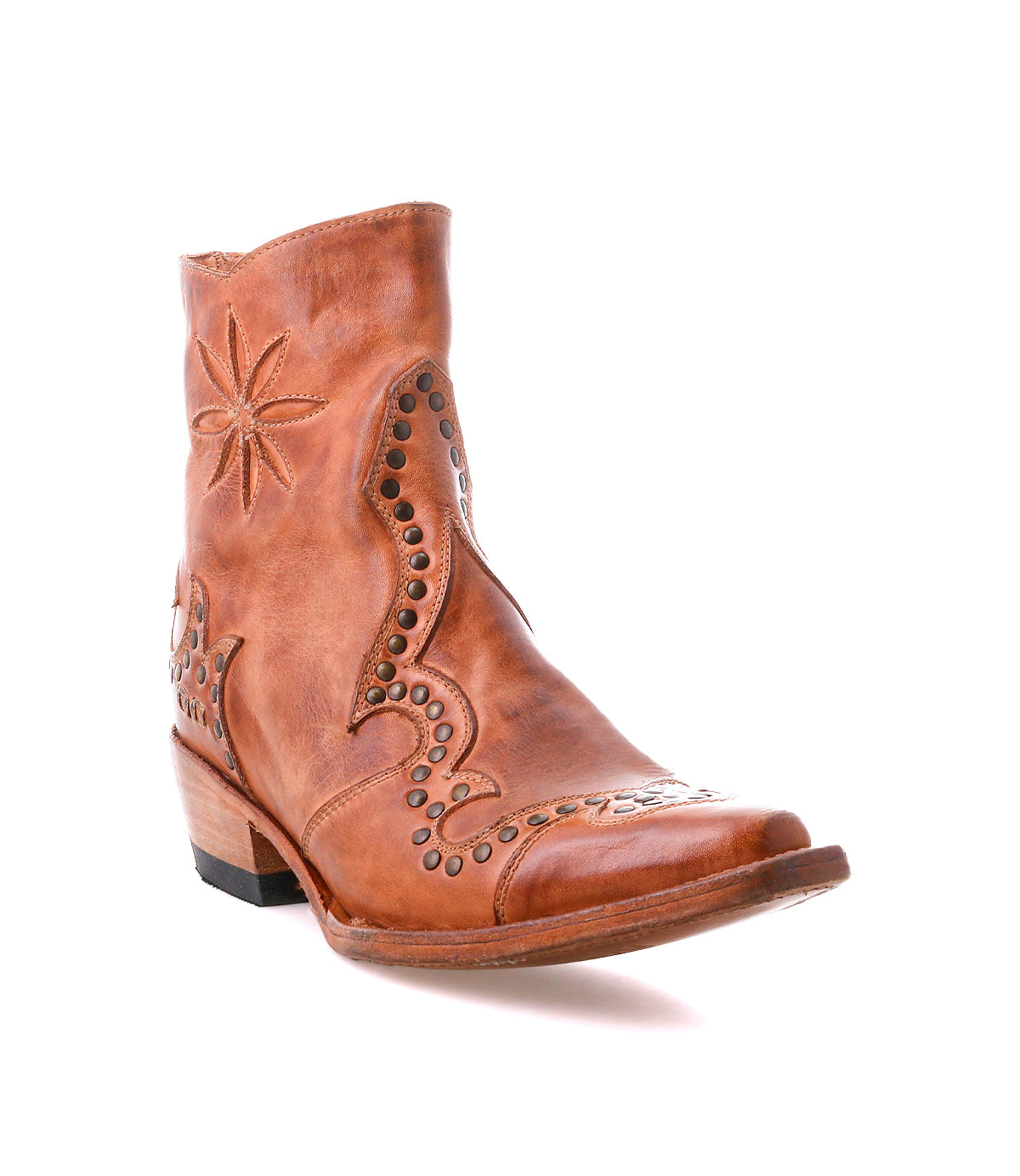 The Frio bootie by Bed|Stü features brown leather with decorative stitching, floral cutout details, antiqued brass studs, a low stacked heel, and a pointed toe, shown photographed on a white background.