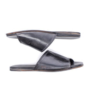 The Bed|Stü Gailee black leather slide sandals are displayed side by side on a white background, with one sandal facing up and the other facing down. Designed for all-day wear, the Gailee slides feature a cushioned footbed that ensures lasting comfort.
