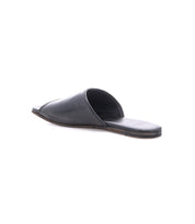 The Bed|Stü Gailee is a black leather slide open-toe flat slip-on sandal, pictured from a rear side angle against a white background. Designed for all-day wear, it offers enhanced support with its cushioned footbed, ensuring lasting comfort.