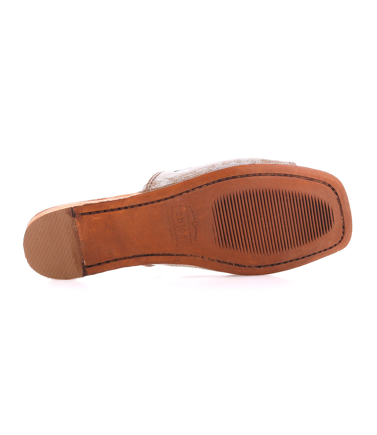 Bottom view of the Gailee by Bed|Stü—a comfortable brown shoe featuring a rubber heel cap and a textured, rectangular sole with horizontal grooves for added grip, complemented by a cushioned footbed for enhanced support.