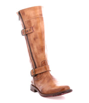 The Bed|Stü Gogo Lug is a tall brown mid-calf leather boot featuring a side zipper, two buckled straps, and a low heel on a sturdy lug outsole, shown against a white background.