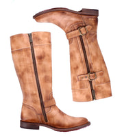 The Bed|Stü Gogo Lug boots are tan leather knee-highs featuring side zippers, decorative buckles, and a sturdy lug outsole, displayed from the side and front against a white background.