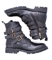 The Bed|Stü Grab boots are a pair of black leather combat boots featuring studded buckle straps, side zippers, and a durable Vibram sole, shown on a white background.