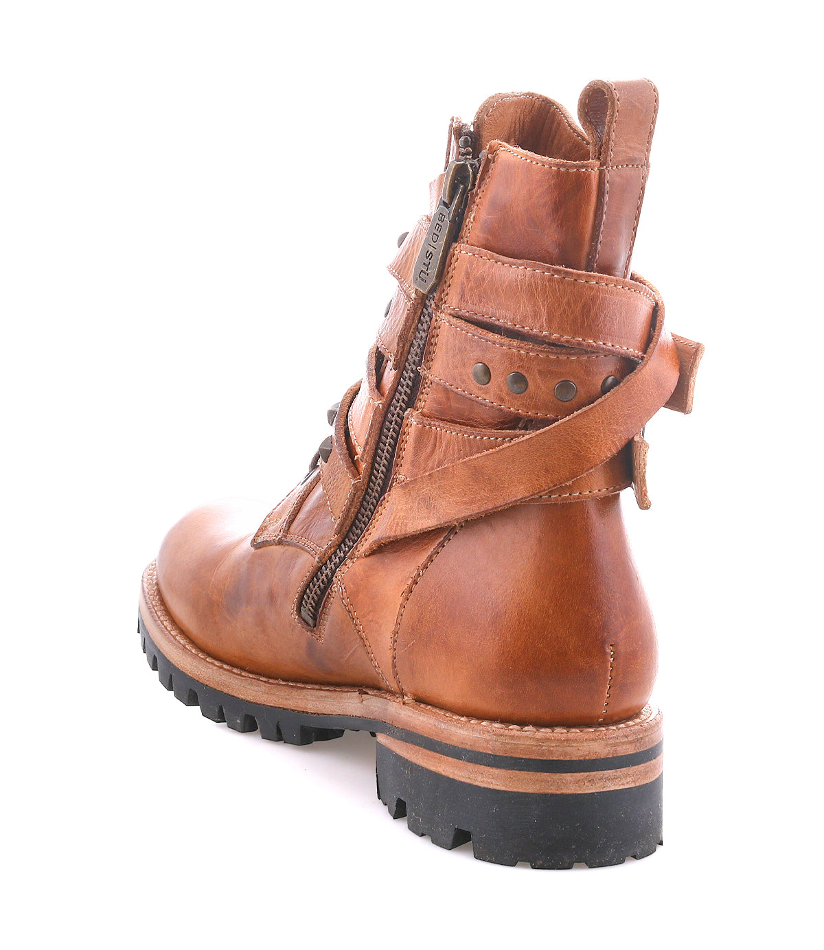 The Bed|Stü Grab is a brown leather combat boot featuring a side zipper, back strap detail, visible stitching, and studded buckle straps for added edge, finished with a rugged black Vibram sole. Shown photographed on a white background.