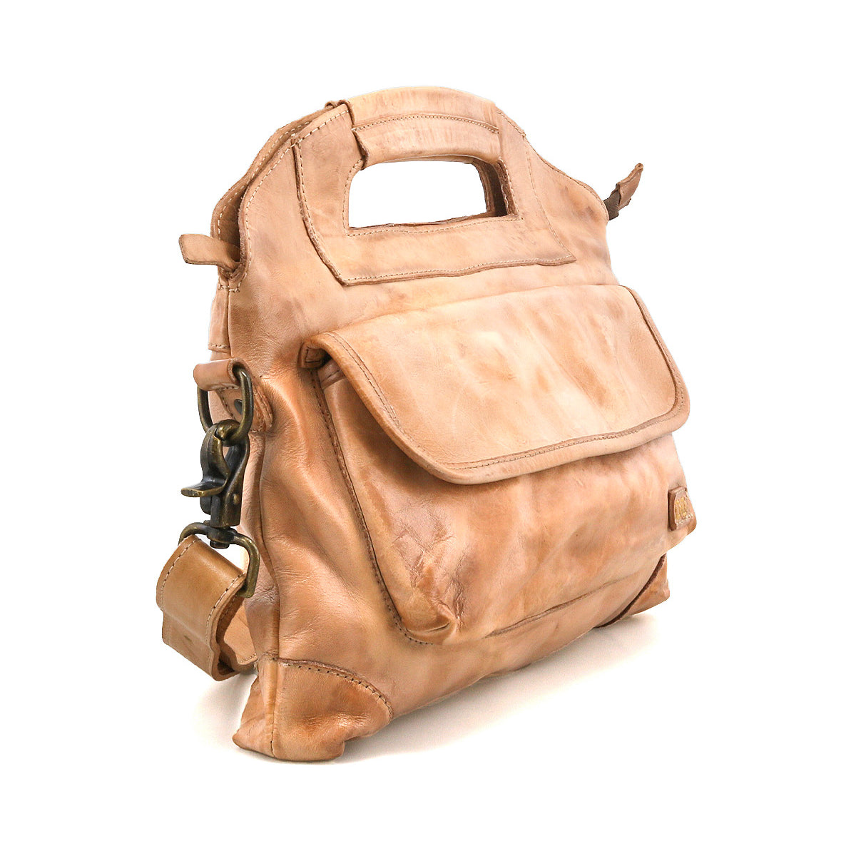 The Bed|Stü Greenway is a light brown full-grain leather handbag with a built-in handle, front flap pocket, and brass buckle accents, featuring a secure zip-top closure and displayed on a white background.