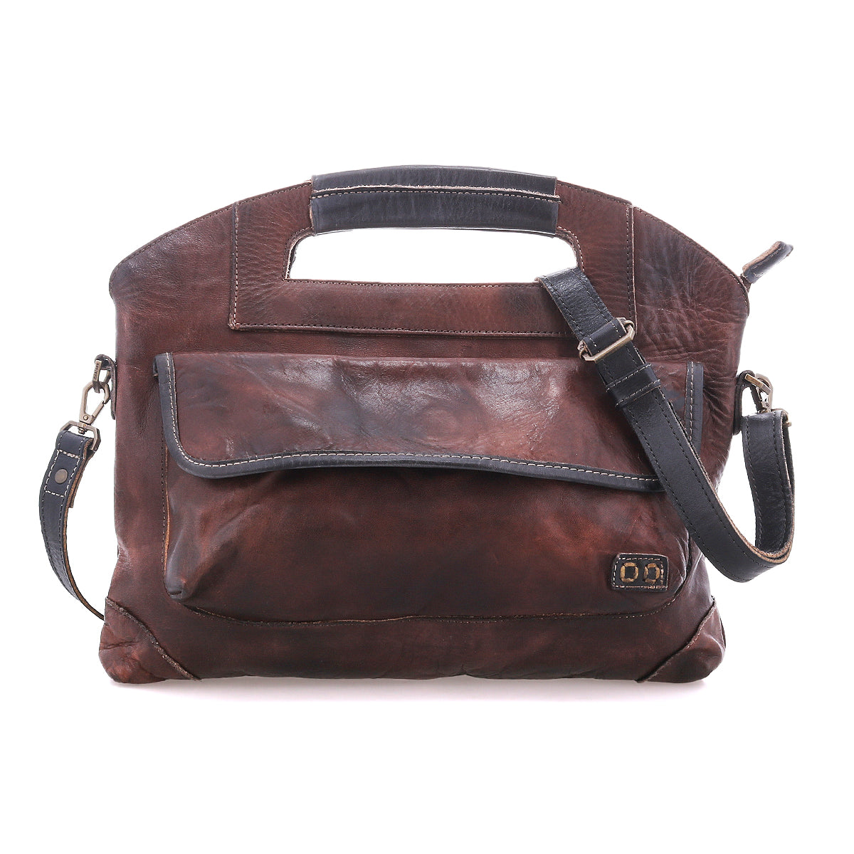 The Bed|Stü Greenway is a brown leather shoulder bag crafted from full-grain leather with black accents, featuring a spacious front pocket, adjustable crossbody strap, integrated top handle, and a secure zip-top closure to keep your essentials safe.