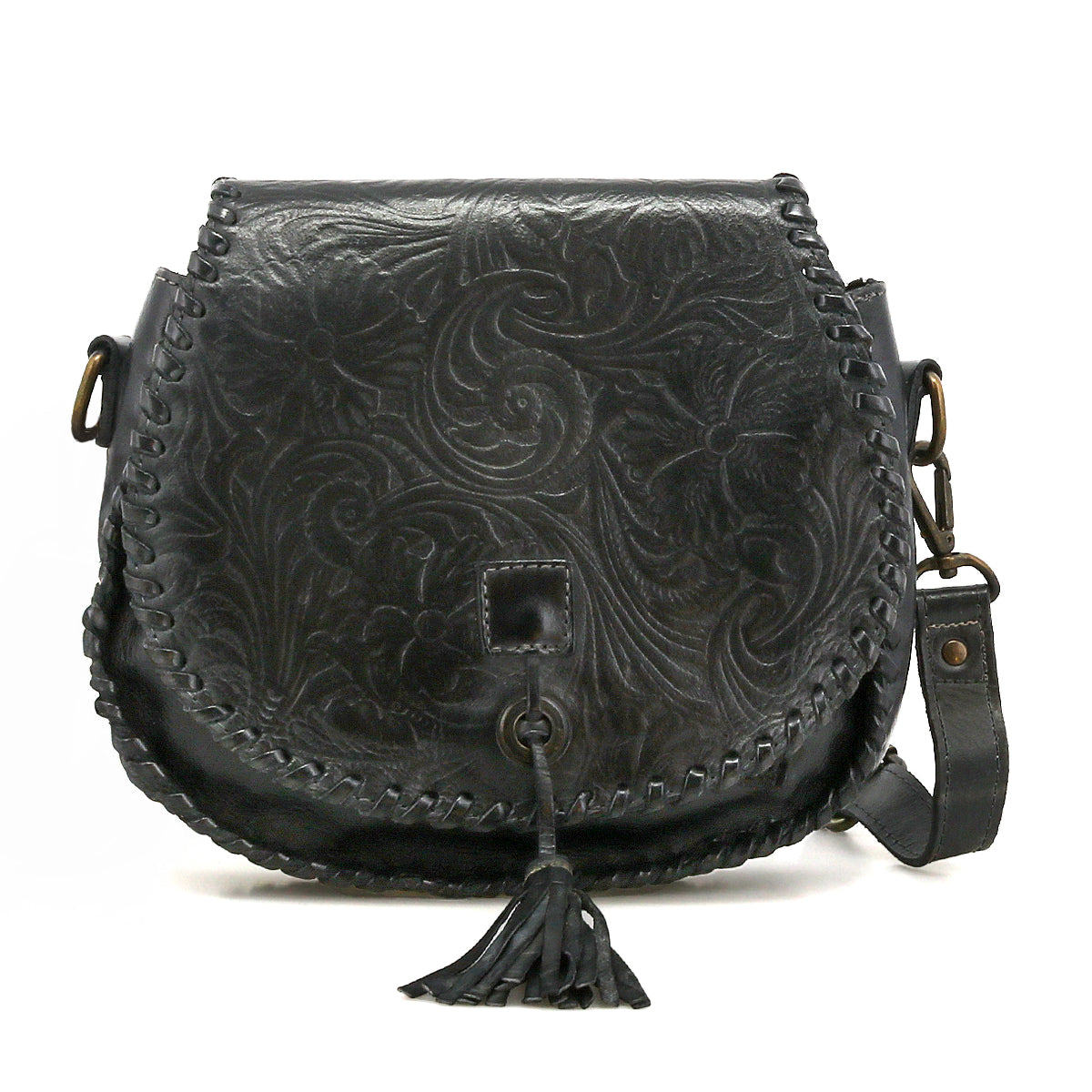 The Bed|Stü Half Moon EM is a black leather saddlebag crossbody purse with floral embossing and whipstitch edges, showcasing an embossed foliage pattern, a front tassel detail, and an adjustable strap for versatile wear.