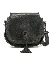 The Bed|Stü Half Moon EM is a black leather saddlebag crossbody purse with floral embossing and whipstitch edges, showcasing an embossed foliage pattern, a front tassel detail, and an adjustable strap for versatile wear.