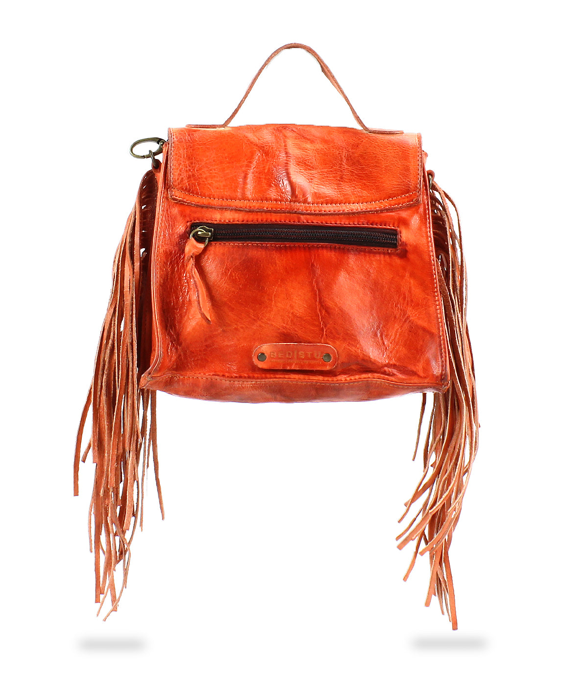 Bed|Stü Hidden orange leather backpack with a structured silhouette, front zipper pocket, top handle, and long fringe details hanging from both sides, displayed on a white background.