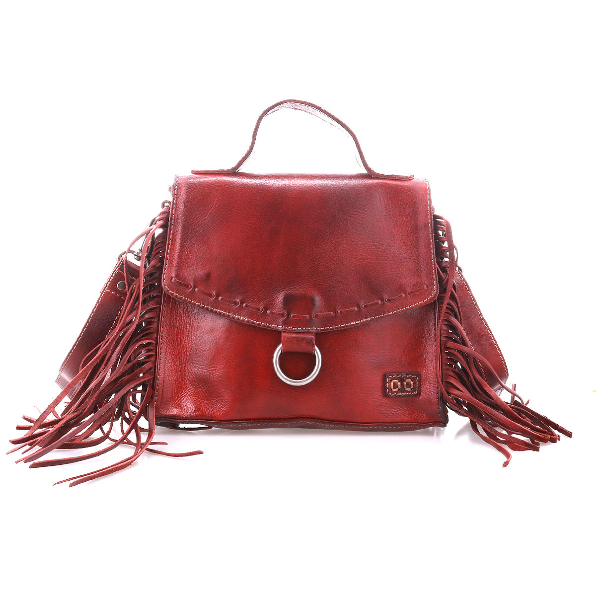 Introducing the Bed|Stü Hidden, a red leather handbag boasting fringe accents on both sides, a sturdy top handle, and a front flap adorned with signature metal ring detailing. Crafted from soft leather with visible stitching and a structured silhouette, this versatile bag also comes with a crossbody strap for effortless carrying.