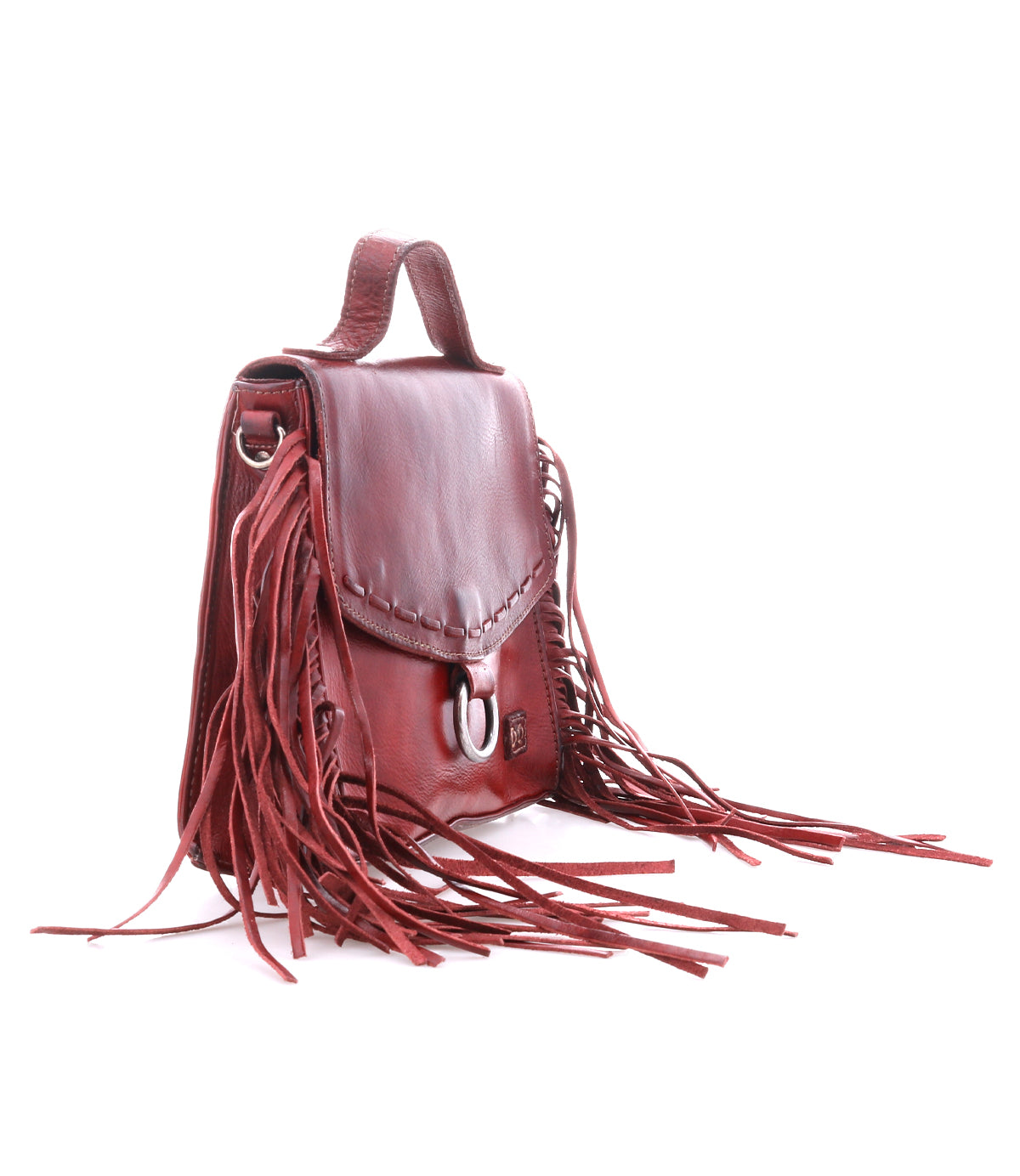 Introducing the Hidden by Bed|Stü—a brown leather handbag with a structured silhouette, featuring a top handle, front flap, silver buckle closure, and long fringe detailing along the sides. Crafted from soft leather, this versatile bag also includes a crossbody strap for added convenience.