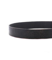 A close-up photo of the Bed|Stü Hobo belt showcases its sleek metal buckle and black leather strap, elegantly curved against a white background—an ideal accessory to elevate your everyday style.
