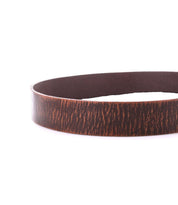A close-up of the Bed|Stü Hobo brown leather belt, featuring a textured finish and metal buckle, laid flat in a circular shape on a white background—perfect for adding everyday style to any outfit.