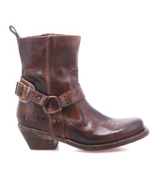 A single Bed|Stü Homage ankle boot in worn brown rich leather, featuring a harness strap and a mid-height stacked heel, is displayed in profile against a white background.