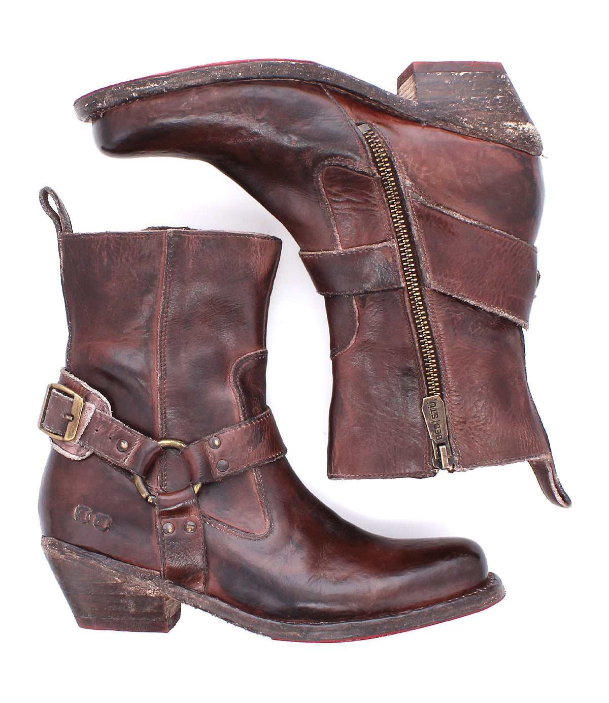 A pair of Bed|Stü Homage boots crafted from rich, worn leather with harness straps, buckles, and side zippers, featuring a square toe design and shown from both the side and bottom views.