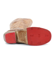 The Bed|Stü Humble boot is pictured sole-up, showcasing its brown leather and square-toe design. The red sole features small embossed horseshoe shapes, displays some wear near the arch, and is complemented by a wooden heel.