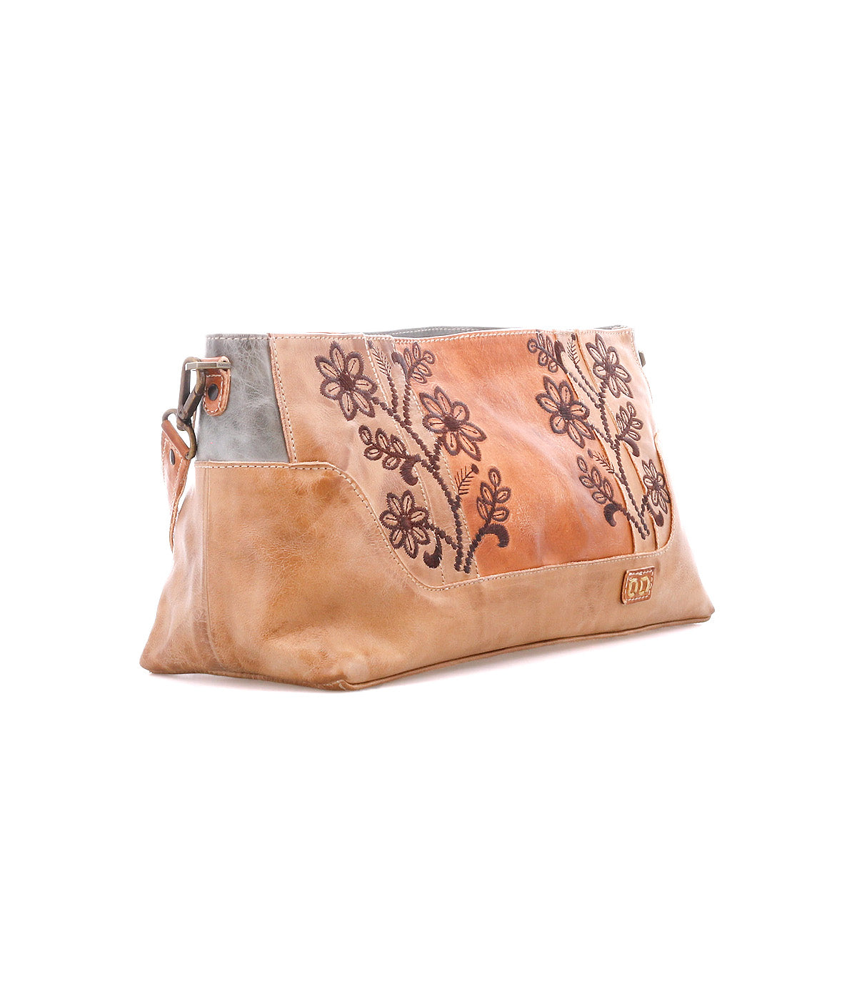 Hyperbolic by Bed|Stü—this tan leather clutch features handcrafted floral embroidery, a metal logo detail, and silver-tone hardware, all showcased against a white background for a bohemian touch.