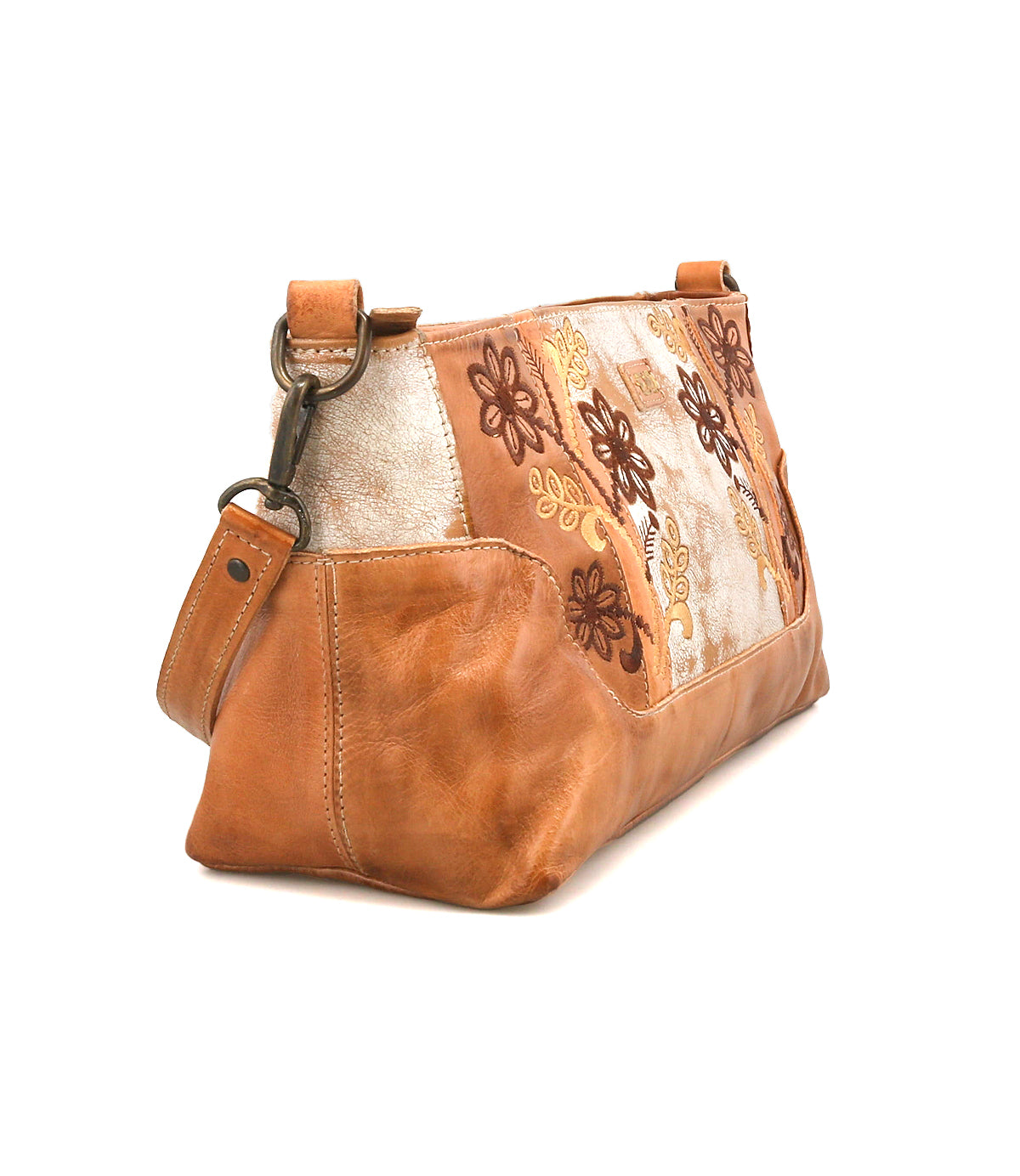 The Bed|Stü Hyperbolic is a tan leather shoulder bag, featuring handcrafted embroidered floral patterns in brown and gold on the side and displayed on a white background. This unique accessory captures a subtle bohemian charm, blending style with individuality.
