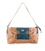 The Bed|Stü Hyperbolic is a beige and teal handcrafted leather shoulder bag featuring floral embroidery, a single strap, and a rectangular shape, perfect for adding a touch of bohemian charm to any outfit.