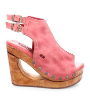 Introducing Imelda by Bed|Stü: a pink cutout wedge peep-toe sandal featuring a wooden platform, dual adjustable ankle buckles, and metallic studs accenting the open-toe silhouette.