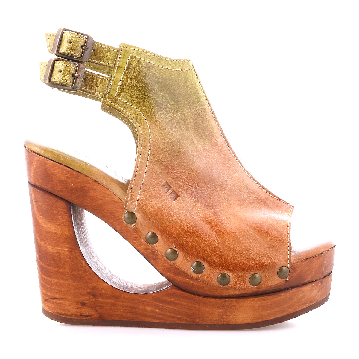 The Bed|Stü Imelda is a brown leather open-toe wedge sandal, showcased in a side view, featuring a stylish cut-out wooden heel, two adjustable ankle buckles, decorative brass rivets, and distinctive cutout wedge detailing.