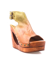The Imelda platform wedge sandal by Bed|Stü features tan leather, an open-toe silhouette, adjustable ankle buckles, brass stud accents, and a wooden sole, shown against a white background.