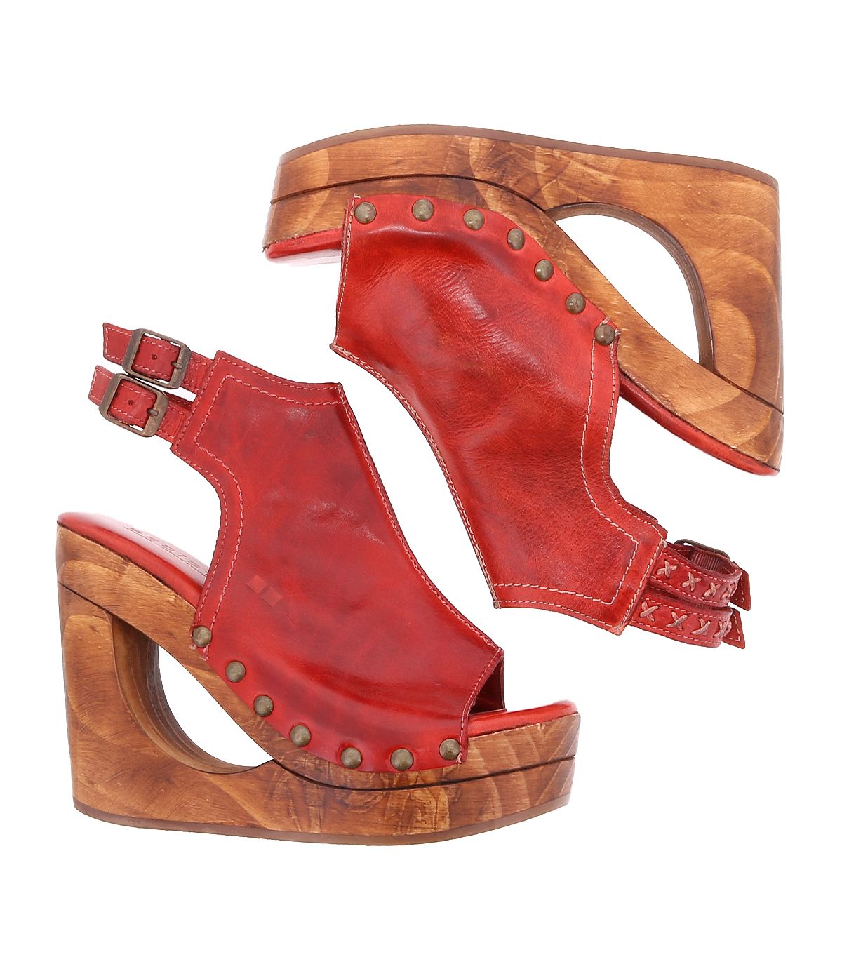 The Imelda wedge sandals by Bed|Stü are crafted from red leather with wooden platforms, studded detailing, and an open-toe design. Featuring double adjustable ankle buckles, the pair is displayed side by side on a white background.