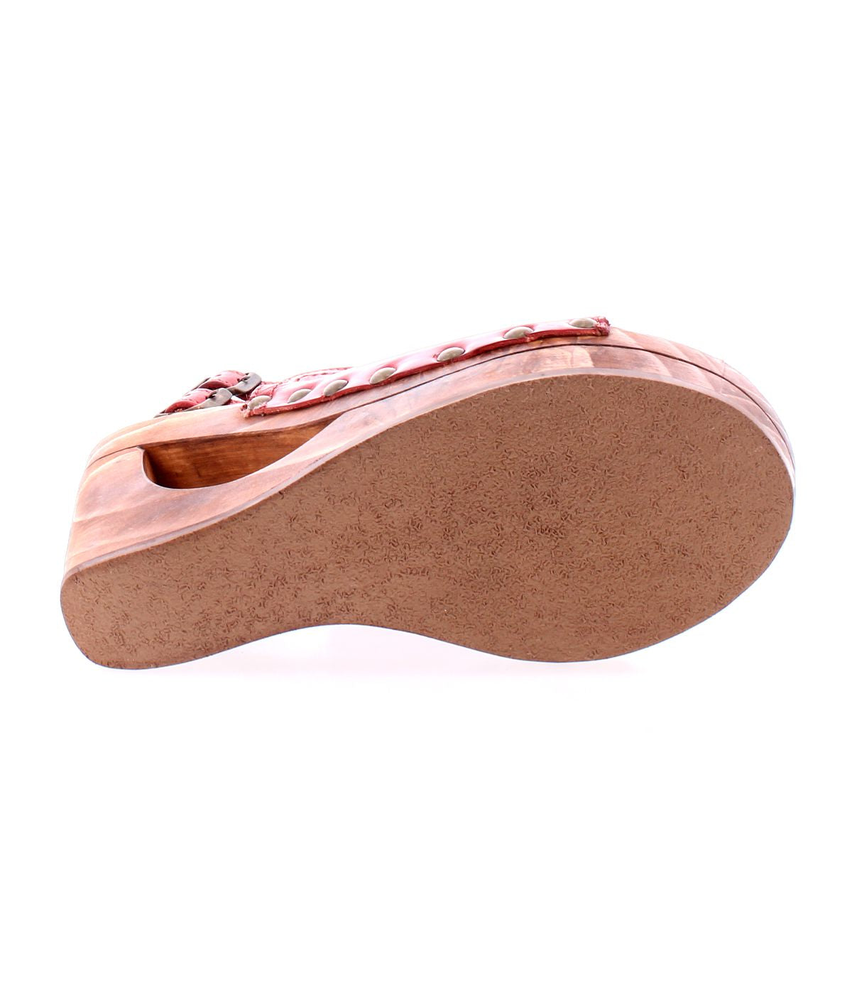 The Bed|Stü Imelda sandal is shown from the bottom, highlighting its textured sole and curved design in a reddish-brown wooden wedge. The open-toe silhouette adds a stylish touch to its overall look.
