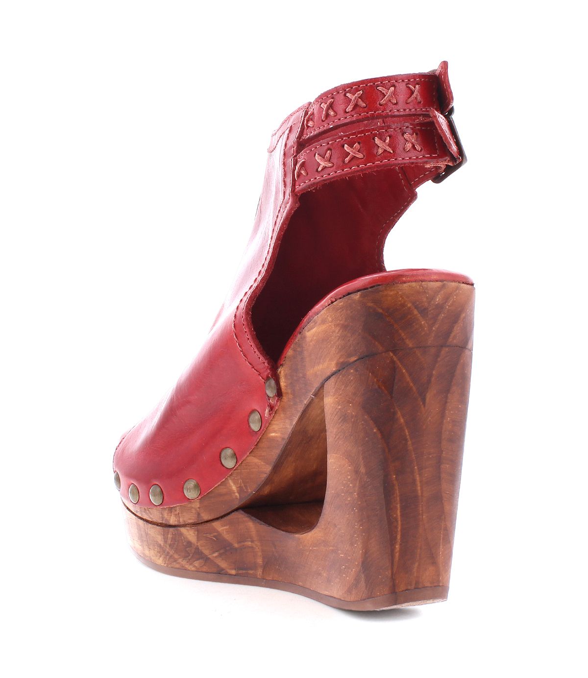 Introducing the Bed|Stü Imelda—a red leather cutout wedge sandal featuring an open-toe design, wooden platform heel, metal stud accents, and an adjustable ankle buckle adorned with X-shaped stitching detail.