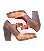 A pair of Bed|Stü Ishtar brown leather Mary Jane pumps featuring adjustable straps and chunky block heels, shown on a white background with one shoe stacked atop the other.
