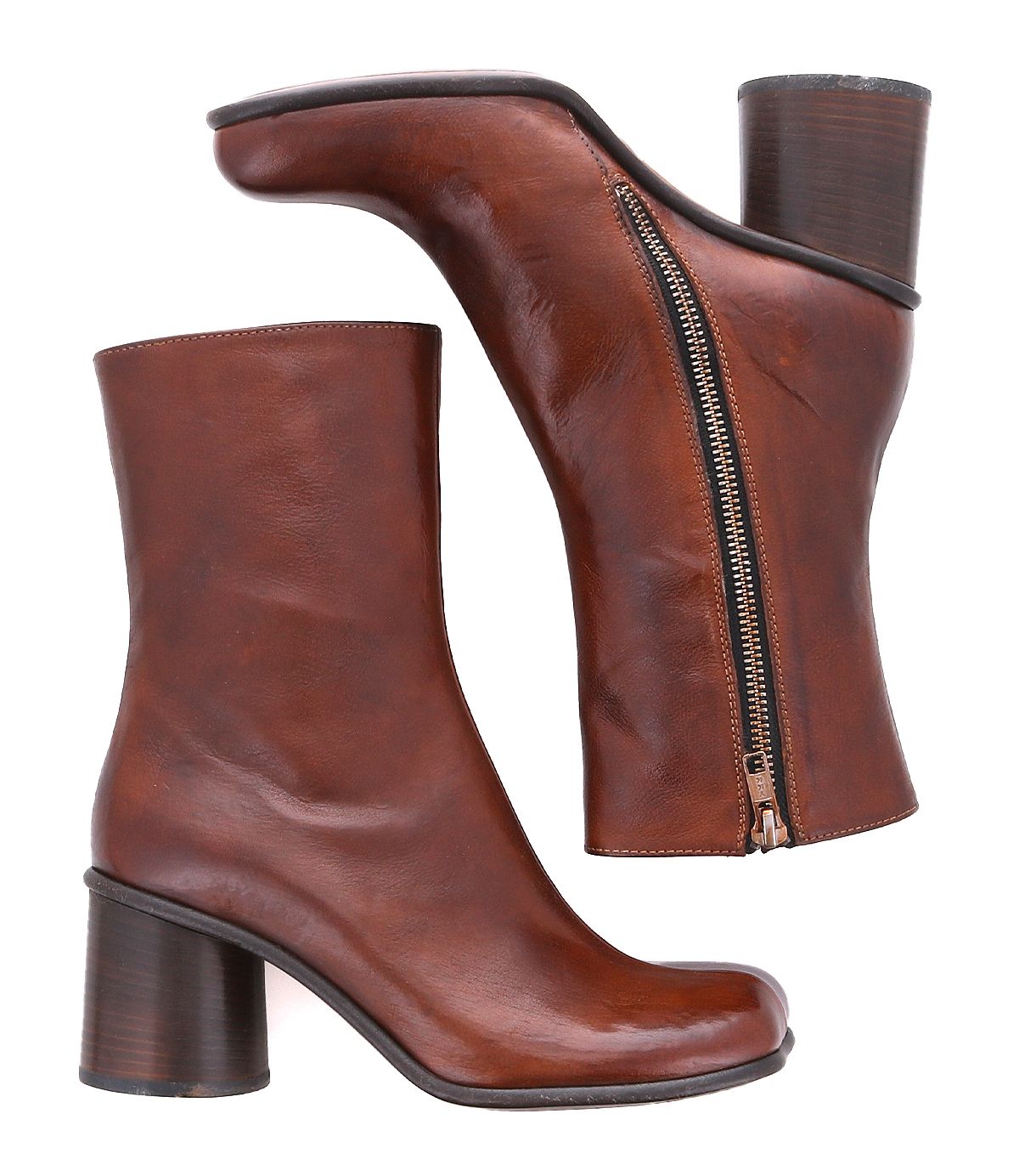 Two brown Isodora ankle boots by Bed|Stü, crafted from Italian leather with round toes, chunky high heels, and side zippers, are displayed—one standing upright and the other lying on its side to highlight the zipper—emphasizing the quality craftsmanship of Bed|Stü’s Italian leather boots.
