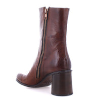 Isodora by Bed|Stü is a brown Italian leather ankle boot featuring a side zipper and chunky high heel, handcrafted with Blake-stitched construction, displayed from a rear side angle on a white background.