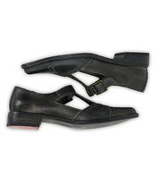 A side-profile image of the Bed|Stü Jenny shoes, featuring black leather Mary Jane T-straps with a low heel, buckle closure, cushioned insole, and light wear on the soles, set against a white background.