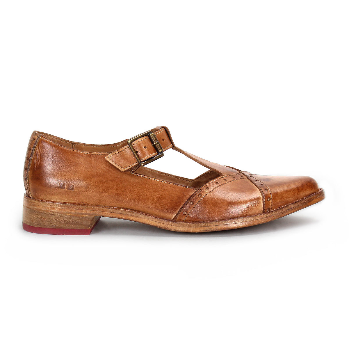The Bed|Stü Jenny is a single brown leather Mary Jane-style T-strap shoe featuring a double buckle, low heel, cushioned insole, and red detailing on the outsole, displayed in profile against a white background.